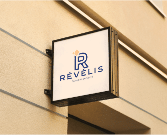 Une plaque au mur avec le logo du centres d imagerie medicale Revelis | Groupe Revelis