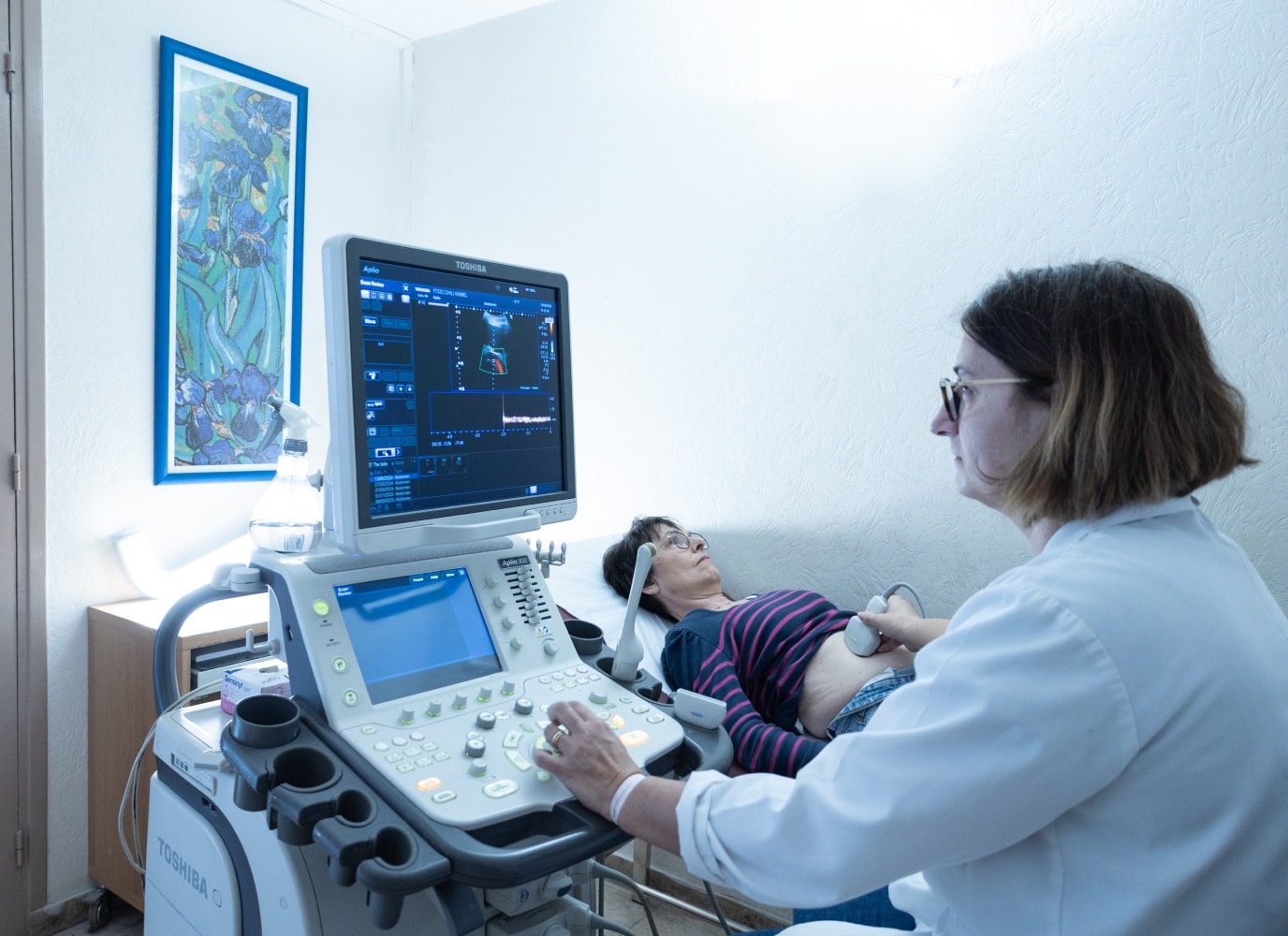 Medecin qui passe une echographie abdominale a une patiente au centre IRM et scanner 18eme | Groupe Revelis